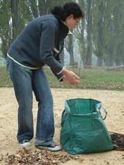 Claudia legt Laub in die Tasche.