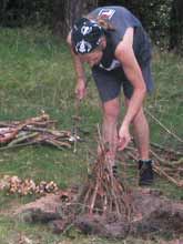 Christian B. stapelt das Holz f&uuml;r das Lagerfeuer.